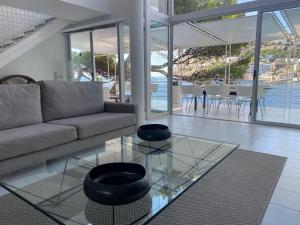 ein Wohnzimmer mit einem Sofa und einem Glastisch in der Unterkunft Villa La Mola in Andratx