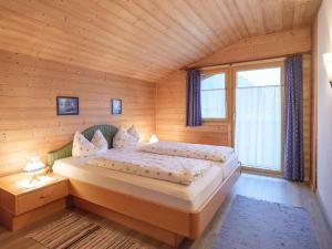 a bedroom with two beds in a wooden cabin at Haus Barbara in Bach