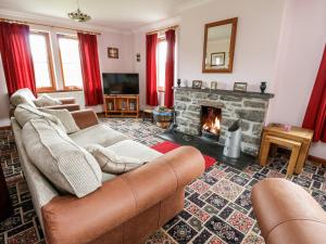 a living room with two couches and a fireplace at Creag-na-Sanais in Laggan
