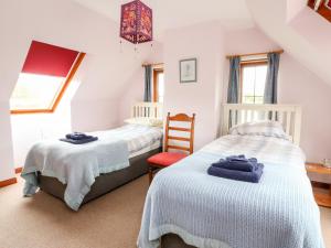 a twin bedroom with two beds and a chair at Creag-na-Sanais in Laggan