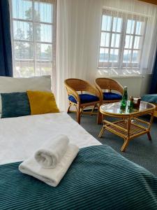 ホルニー・プラナーにあるHotel Na Plážiのベッド、テーブル、椅子が備わるホテルルームです。