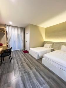 ein Hotelzimmer mit 2 Betten und einem Schreibtisch in der Unterkunft Srikij GardenHome Resort in Sa Kaeo