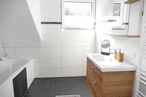 een witte badkamer met een wastafel en een spiegel bij Appartement Mauterndorf in Mauterndorf