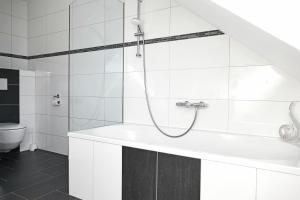 biała łazienka z prysznicem i umywalką w obiekcie Appartement Mauterndorf w mieście Mauterndorf +37 zdjęć