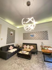 ein Wohnzimmer mit einem Sofa und einem Kronleuchter in der Unterkunft Sziv Apartment - Modern and Comfortable in Budapest