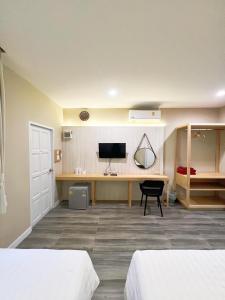 a room with two beds and a desk with a computer at Srikij GardenHome Resort in Sa Kaeo