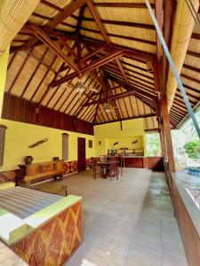 a large living room with wooden ceilings and a table at Villa Bulan Madu Gili Air in Senaru