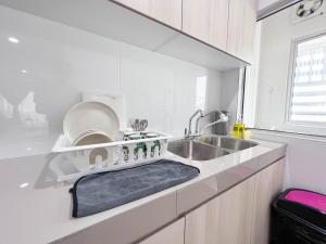a white kitchen with a sink and a dish rack at MH Maison by Manhattan Group in Kuala Lumpur +193 photos