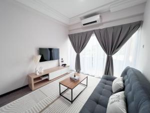 a living room with a blue couch and a tv at MH Maison by Manhattan Group in Kuala Lumpur