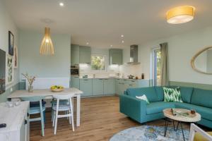 a living room with a blue couch and a table at Center Parcs Eifel Mosel Nürburgring in Gunderath