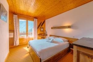 a bedroom with a bed and a large window at Chalet Corzelet ski in - ski out - Happy Rentals in Chamonix-Mont-Blanc