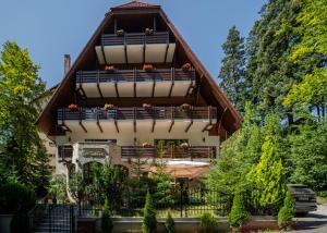 a house with a balcony with flowers on it at Opus Villa in Sinaia