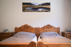 a bedroom with two beds and a painting on the wall at Mountain Lodge Ze Seewjinu - above Zermatt in Zermatt