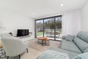 un soggiorno con un divano e una TV di Villa Paraiso - By SCH a São Martinho do Porto