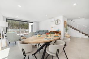 una sala da pranzo e un soggiorno con tavolo e sedie di Villa Paraiso - By SCH a São Martinho do Porto