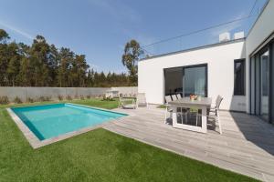 un cortile con piscina e tavolo di Villa Paraiso - By SCH a São Martinho do Porto