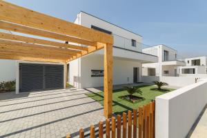 un cortile con pergolato in legno e una casa di Villa Paraiso - By SCH a São Martinho do Porto