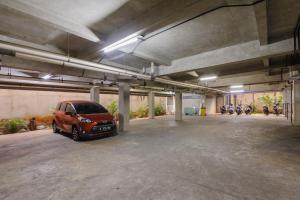 a parking garage with a car parked in it at Sans Stay Caverna Gandaria in Jakarta