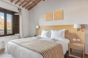 Un dormitorio con una gran cama blanca y una ventana en Palazzo Catalani Resort en Soriano nel Cimino