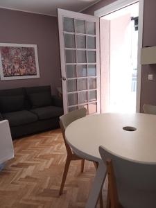 un soggiorno con tavolo bianco e divano di Casa Melé 2, Parking privado opcional a Lleida