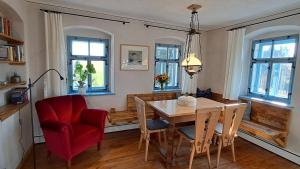 une salle à manger avec une table et une chaise rouge dans l'établissement Ferienhaus FERGUNNA, à Marienberg