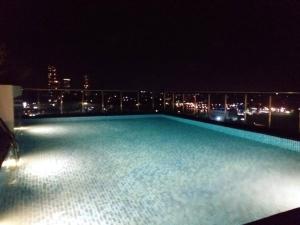 uma grande piscina no topo de um edifício à noite em Capital TRUST Residencies Kotte em Sri Jayewardenepur- Kotte