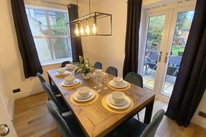 uma sala de jantar com uma mesa de madeira e cadeiras em The Old Bank Beautiful Cotswold House with Huge Garden em Mickleton