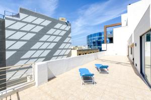 two blue chairs on the roof of a building at 1BR penthouse with Large Private Terrace in PV by 360 Estates in St. Julianʼs