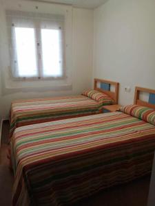 2 camas en una habitación con ventana en Vista Bella Rubielos, en Rubielos de Mora