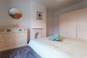 een slaapkamer met een bed, een dressoir en een spiegel bij Cosy home in City Centre in Lincolnshire