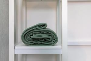 a green coil of rope sitting on a white shelf at Cosy home in City Centre in Lincolnshire