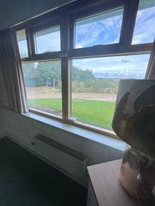 een raam met uitzicht op een grasveld bij Newera Farm in Canley