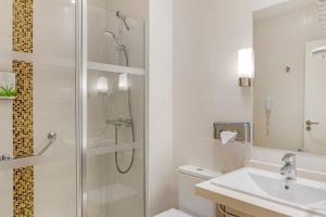 a white bathroom with a shower and a sink at Royal Sunset Beach Club in Adeje