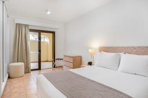 a bedroom with a large white bed and a desk at Royal Sunset Beach Club in Adeje