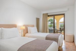 two beds in a hotel room with a balcony at Royal Sunset Beach Club in Adeje