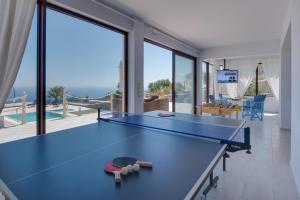 a ping pong table in a living room with a view of the ocean at Sea Views at villa Anemomylos with Heated Pool, Ping Pong and Tennis in Agia Pelagia