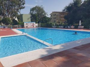 ein großer blauer Pool mit einer Person darin in der Unterkunft Apartamento Edificio Lirios Politur in Platja  d'Aro