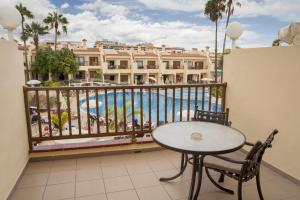 a balcony with a table and a view of a pool at Royal Sunset Beach Club in Adeje