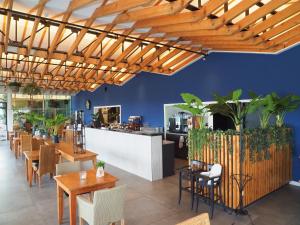 a restaurant with wooden ceilings and tables and chairs at HarTeluk Joure in Joure