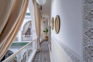un pasillo con escaleras blancas con azulejos azules y blancos en Riad HAFSSA & Spa, en Marrakech
