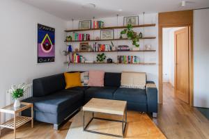 salon z niebieską kanapą i półkami na książki w obiekcie Nadwiślańska11 - Klimatyczny apartament tuż nad Wisłą w Krakowie