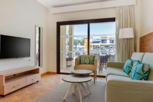 a living room with a tv and a couch and a table at Royal Sunset Beach Club in Adeje