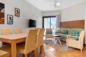 a living room with a table and chairs and a couch at Royal Sunset Beach Club in Adeje