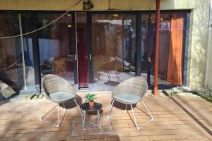 duas cadeiras e uma mesa com uma planta num pátio em Lux & Cozy Apt + Garden +Jaccuzi em Antuérpia