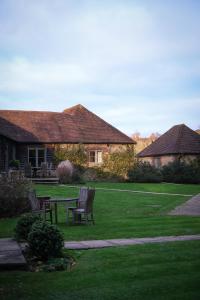 a house with a table and chairs in a yard at Cowdray Holiday Cottages in Midhurst