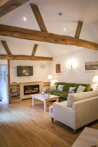a living room with a couch and a fireplace at Cowdray Holiday Cottages in Midhurst