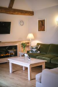 uma sala de estar com um sofá e uma mesa de centro em Cowdray Holiday Cottages em Midhurst