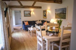 a living room with a table and a couch at Cowdray Holiday Cottages in Midhurst