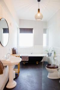 a bathroom with a tub and a toilet and a sink at Orange Door Bnb in Currency Creek