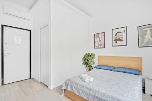 - une chambre avec un lit et un mur blanc dans l'établissement GP10 Bicocca-Villa San Giovanni -WIFI-, à Milan